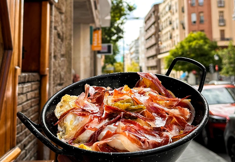 Sartén de huevos rotos con jamón y pimientos